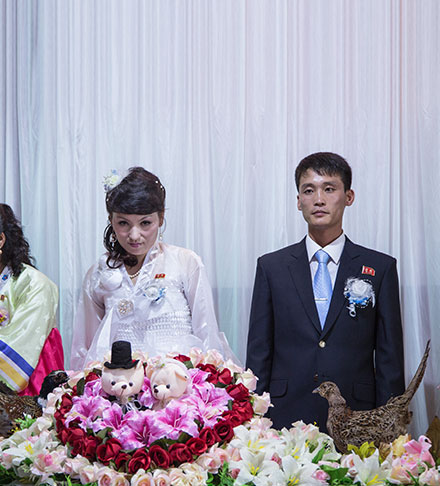 North Korean groom and bride in front of the wedding cake