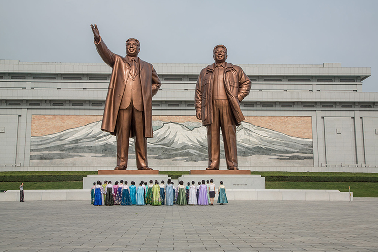 Local guides and ladies pay respect to the Cult of Kim at The Mansudae Grand Monument in Pyongyang.